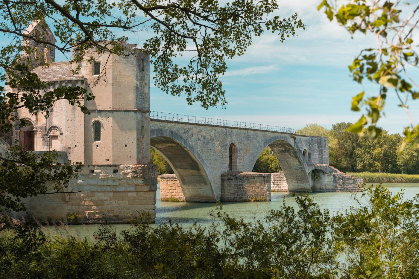 A stone bridge over water is seen here
