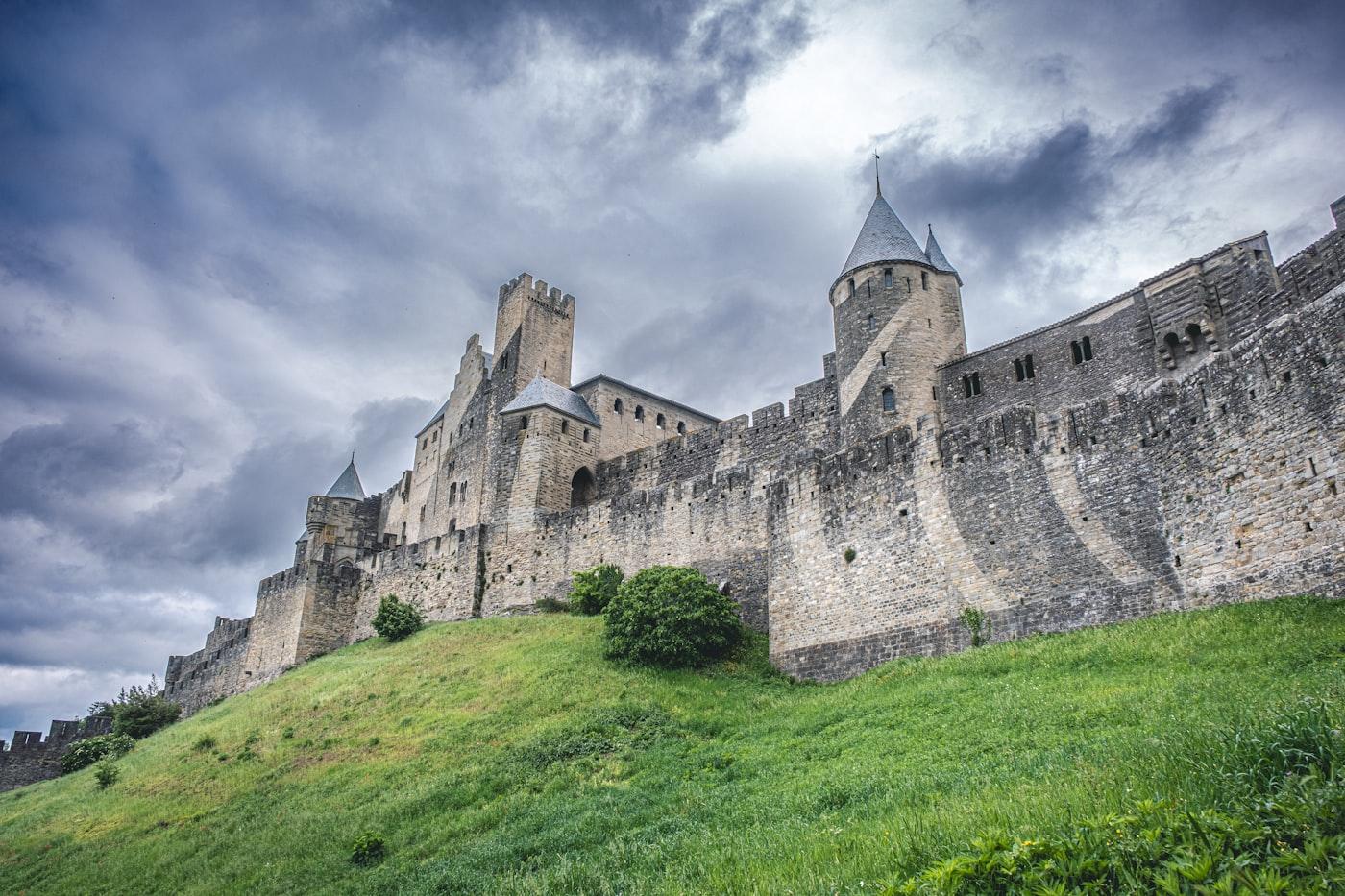 An imposing castle stands against a cloudy sky