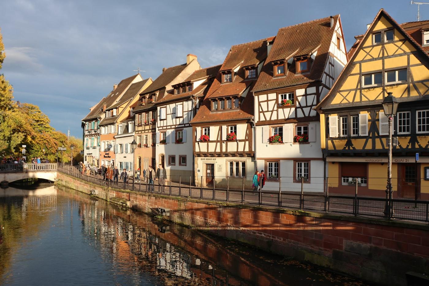 Half-timbered houses line a canal with reflections
