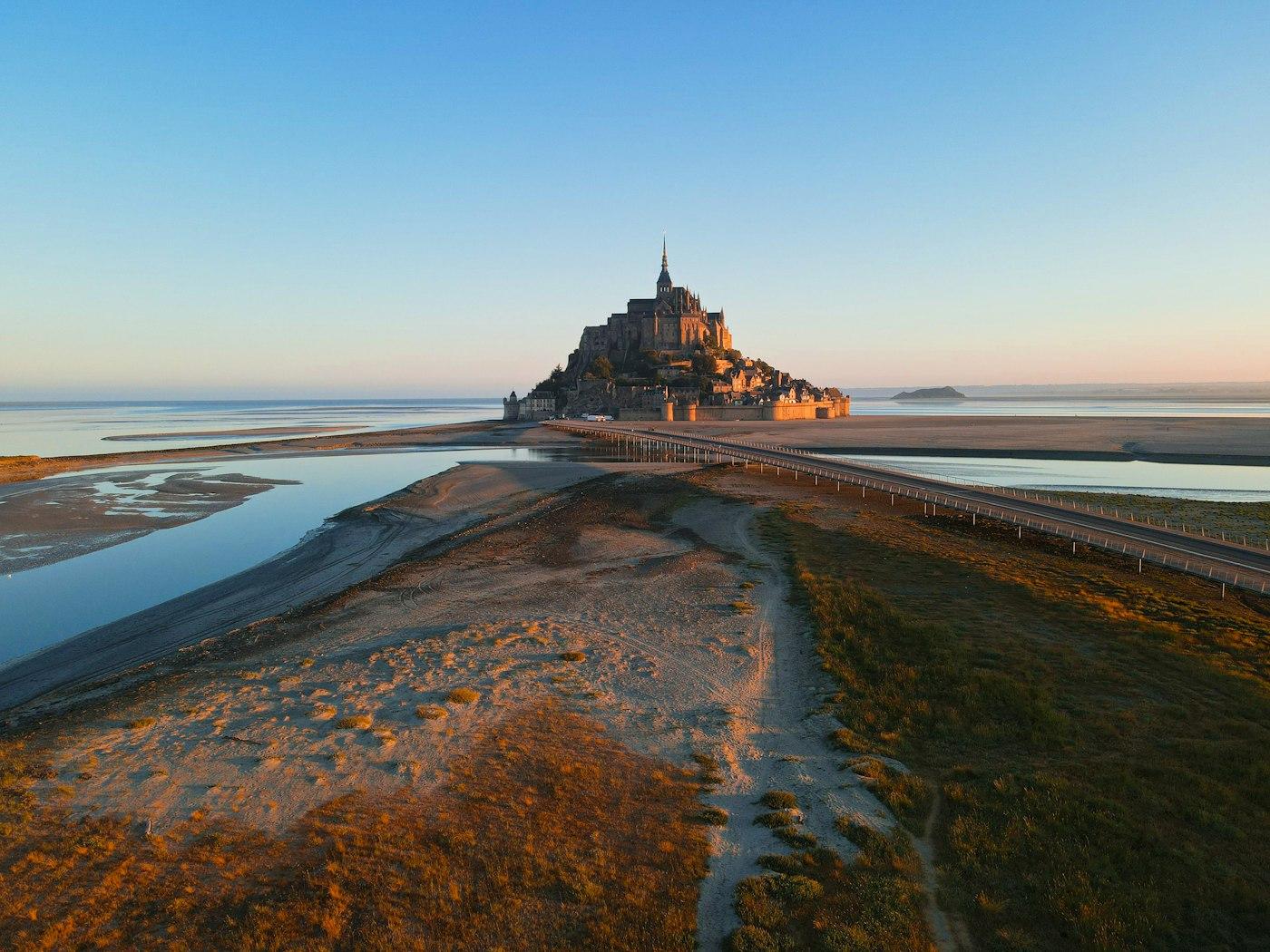 A large castle sitting on top of a beach next to a body of water