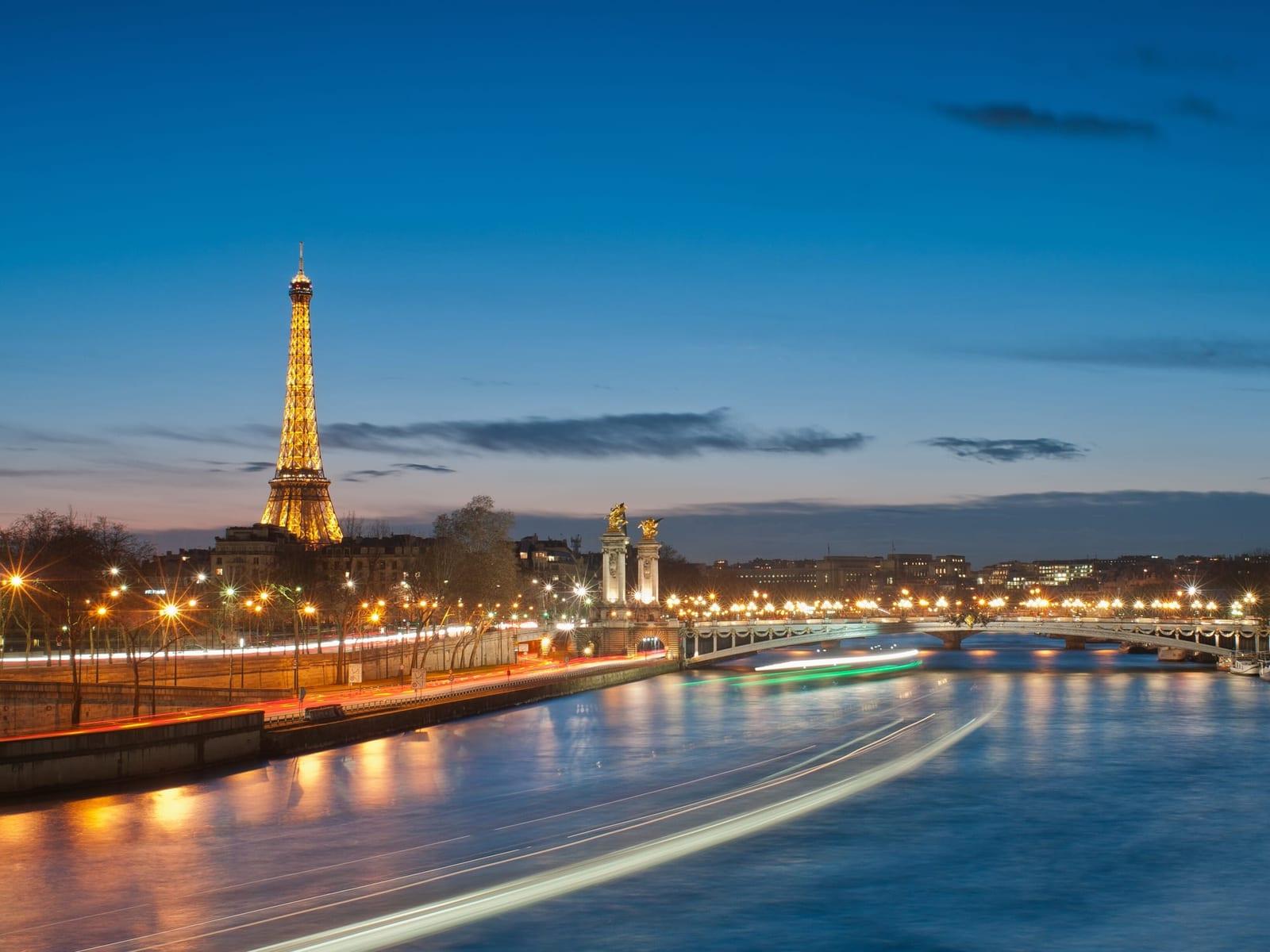 The Eiffel Tower and the Pont Alexandre III lit at dusk